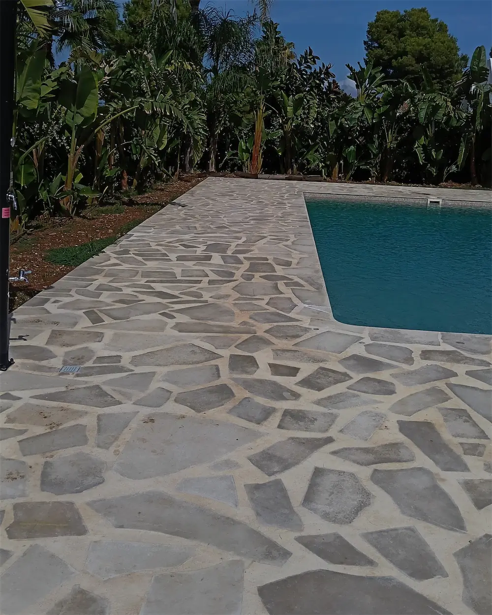 Pérgola de cañizo junto a una piscina, con el adoquín recién puesto